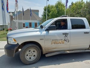 Officer sits in driver's seat of Mackinac Island Police truck in front of Mackinac Island Police Department