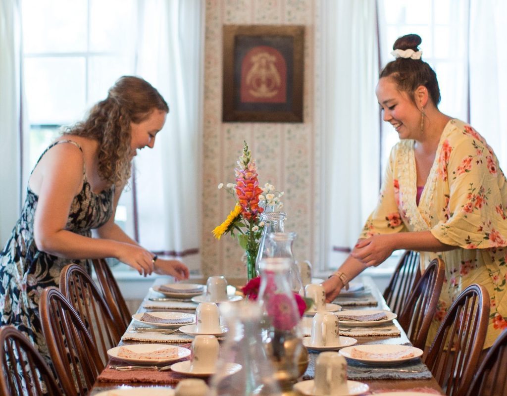 Innkeepers at Haan’s 1830 Inn bed and breakfast on Mackinac Island prepare a table for a meal at the B&B.