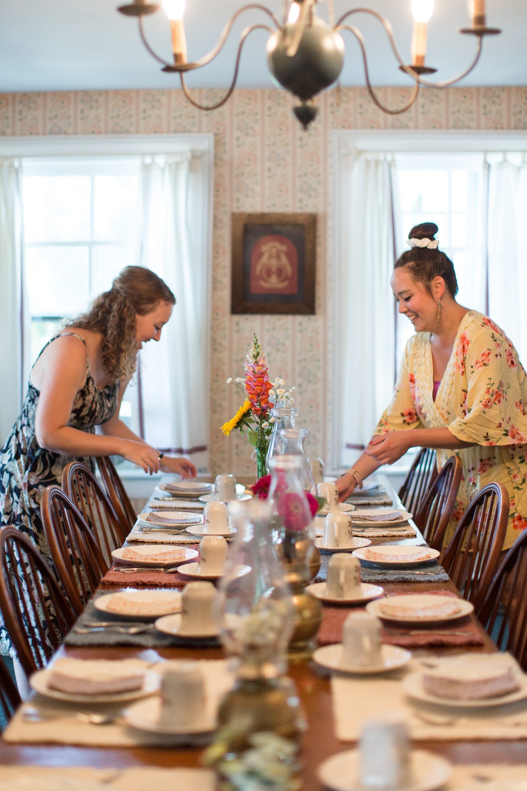 Innkeepers at Haan’s 1830 Inn bed and breakfast on Mackinac Island prepare a table for a meal at the B&B.