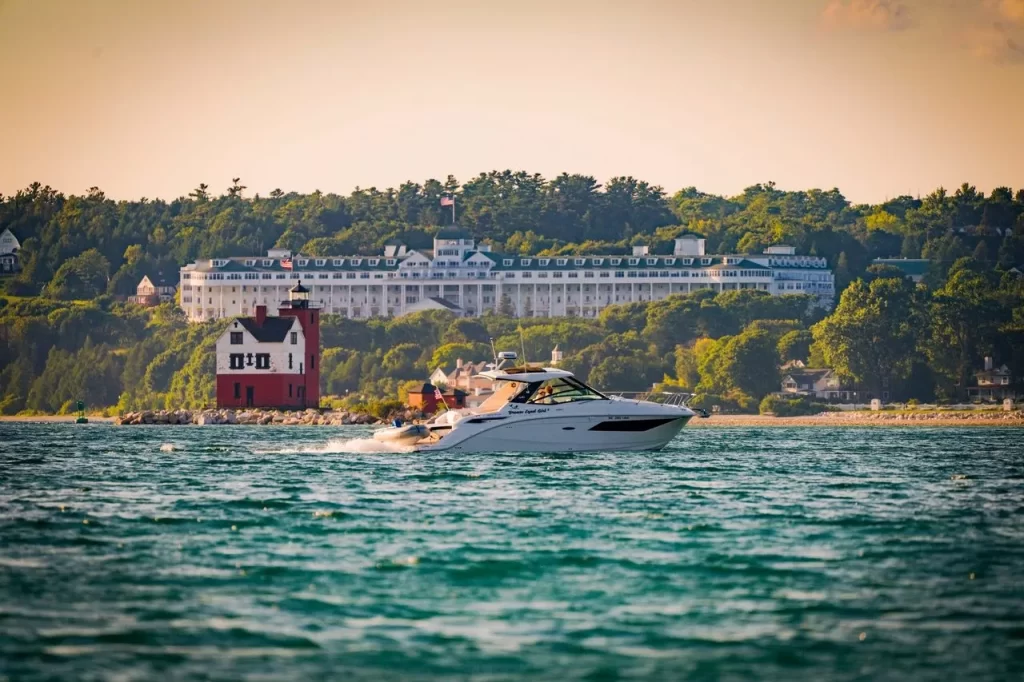 Brown Eyed Girl charter boat passes by Round Island Lighthouse with Mackinac Island’s Grand Hotel in background