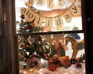 Toys and a “Happy Holidays” sign fill the showroom window of a Mackinac Island storefront.