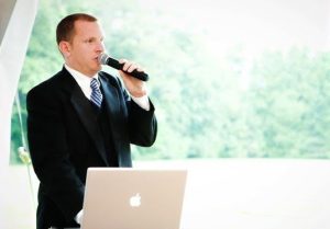 Wedding DJ with Microphone in Front of Laptop on Mackinac Island
