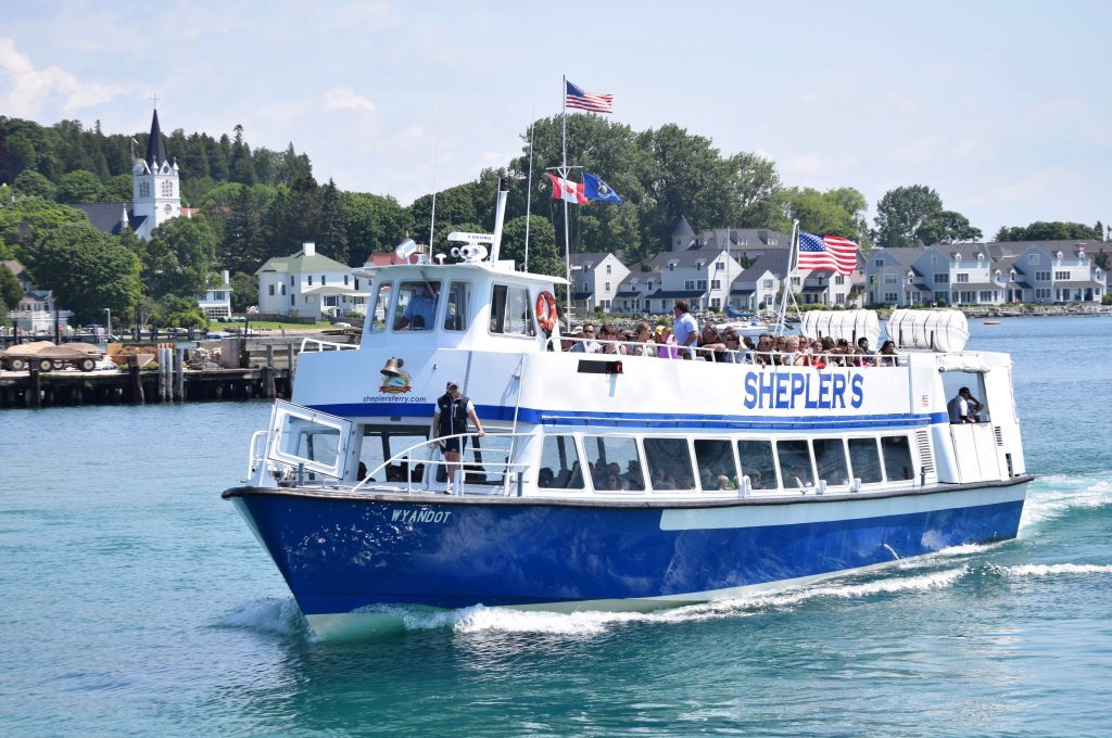 A Shepler's ferry boat full of travelers plies the water off Mackinac Island