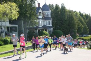 Runners and walkers pass by a Mackinac Island cottage on the bluff during one of the island's annual road races