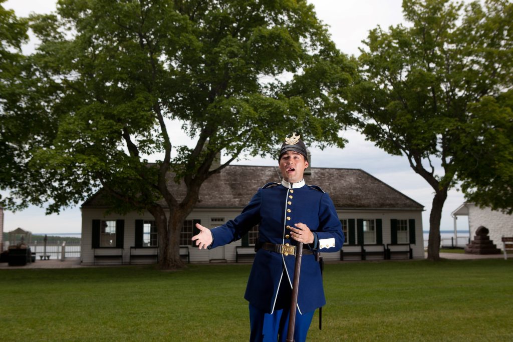 A historical interpreter speaks on the grounds of Mackinac Island's historic Fort Mackinac