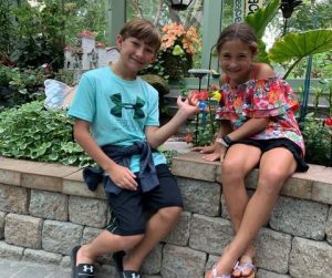 Two kids have a close up encounter with butterflies at the Wings of Mackinac conservatory on Mackinac Island.