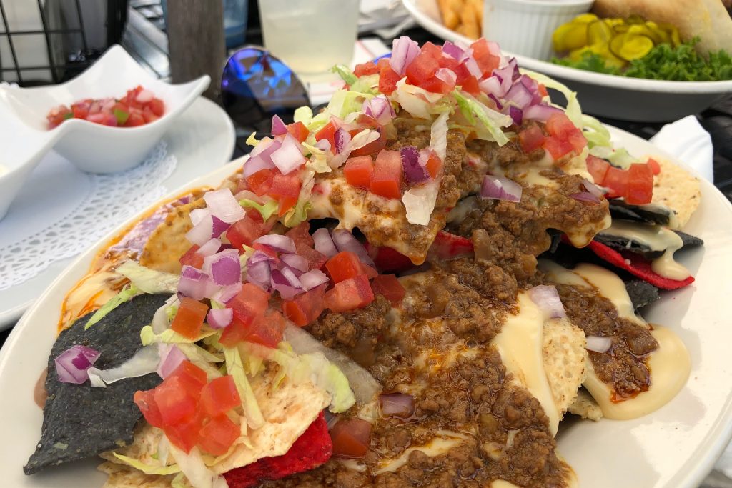 A plate of tortilla chips topped with beef, tomatoes, onions and lettuce on Mackinac Island