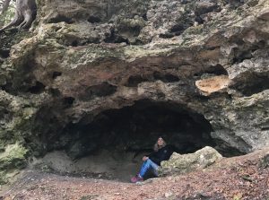 A woman sits inside Eagle Point Cave within the wilderness of Mackinac Island State Park