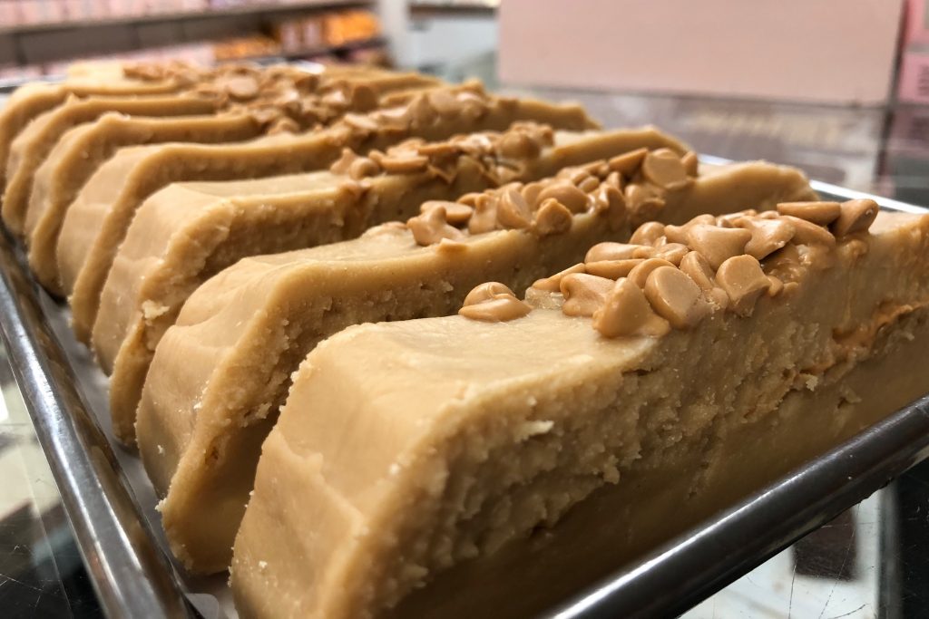 A loaf of brown peanut butter fudge topped with chips and cut into slices of world-famous Mackinac Island fudge