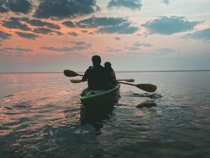 A couple paddles through the still, quiet waters off Mackinac Island on a sunrise kayak excursion