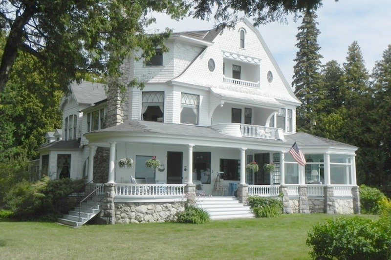 A large white Victorian cottage basks in the summer sun on a glorious summer day on Michigan’s Mackinac Island