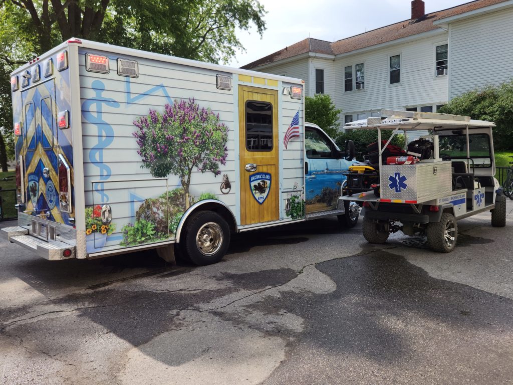 The Mackinac Island EMS ambulance features custom graphics depicting island scenes such as a horse drawn carriage and lilacs