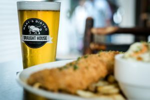 A beer stands behind a plate of food on a table at Mary's Bistro Draught House on Mackinac Island