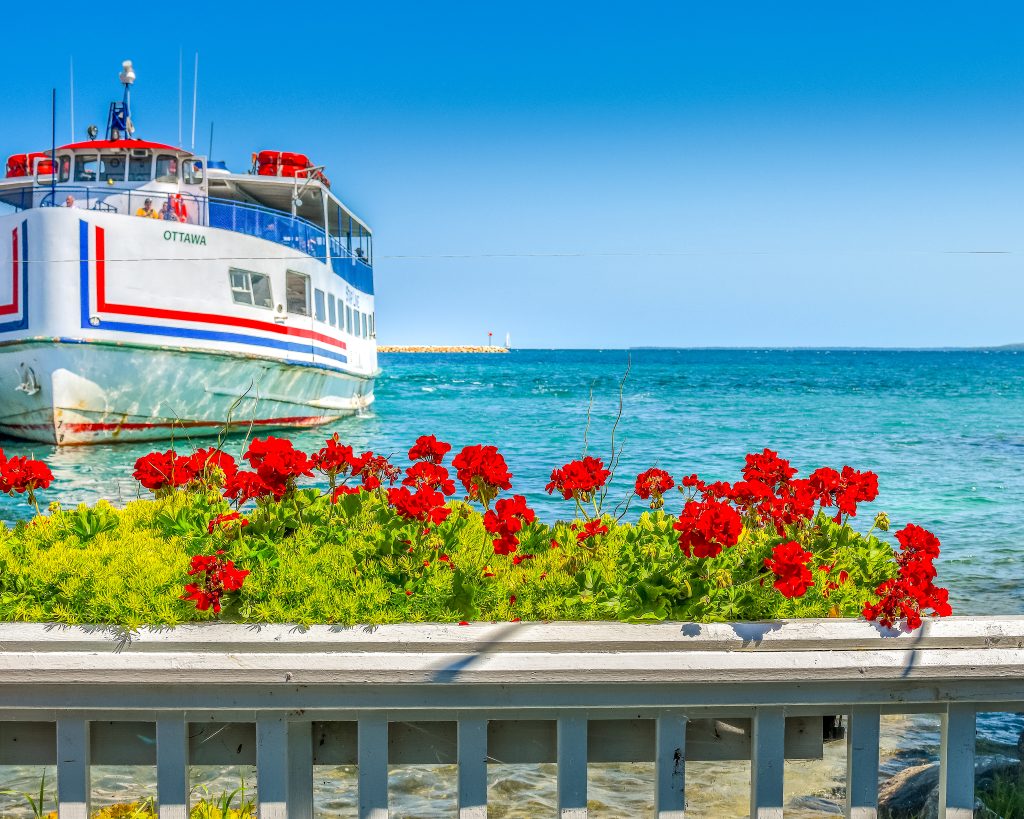 Patio views of vibrant blue water and a ferry boat at Mary's Bistro Draught House on Mackinac Island