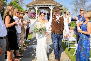 A bride and groom walk down the aisle after getting married in an outdoor ceremony at Mackinac Island's Mission Point Resort