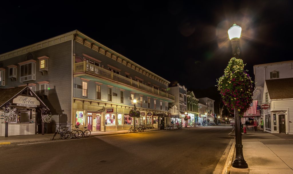 A lamppost illuminates the Murray Hotel with bikes parked out front at night on Mackinac Island’s Main Street