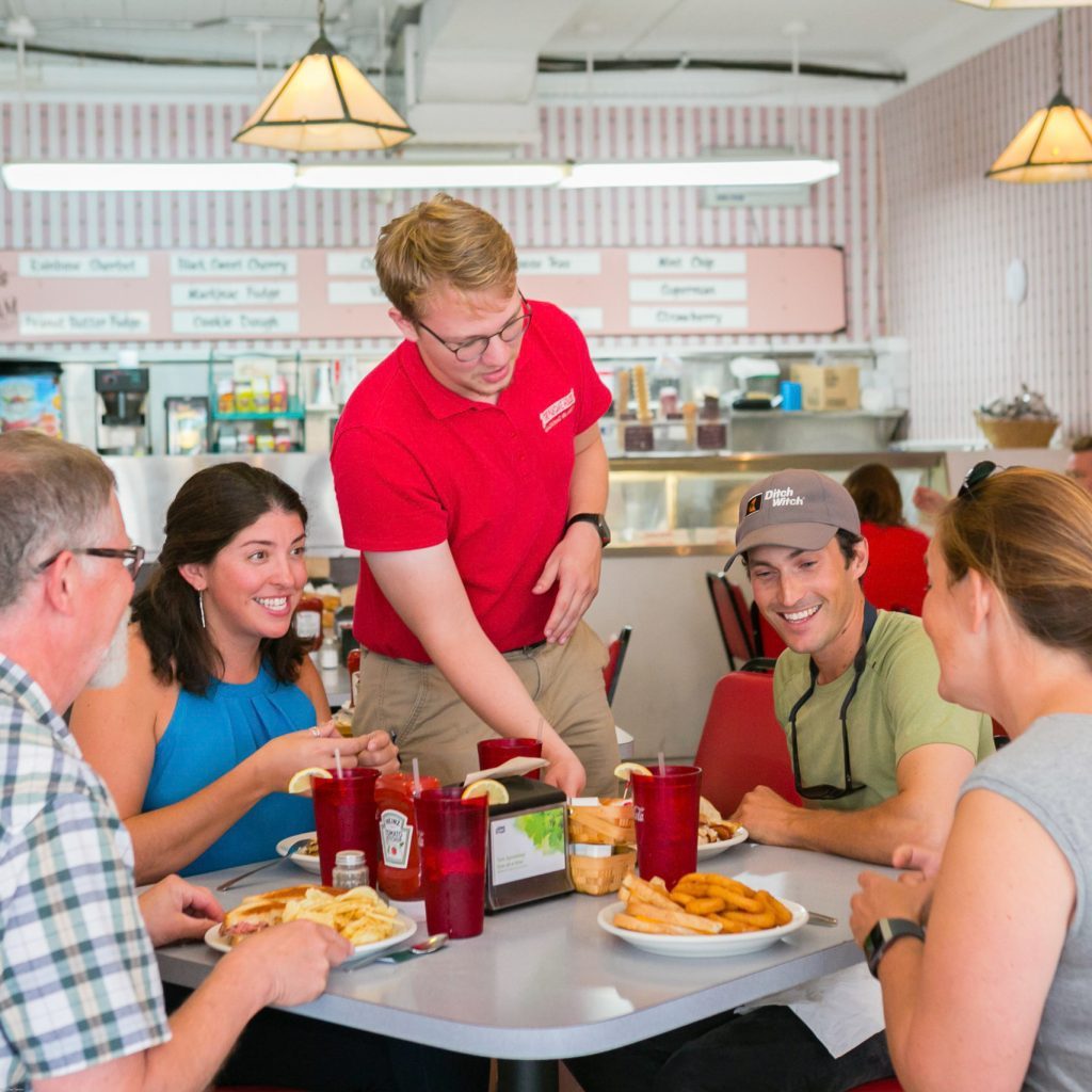 A waiter serves a party of four at one of Mackinac Island’s many restaurants that serve breakfast.