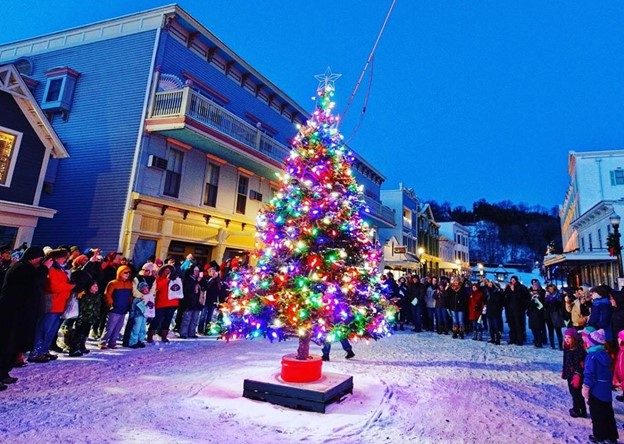 Mackinac Island Christmas tree all lit up in middle of Main Street with crowd at tree-lighting ceremony