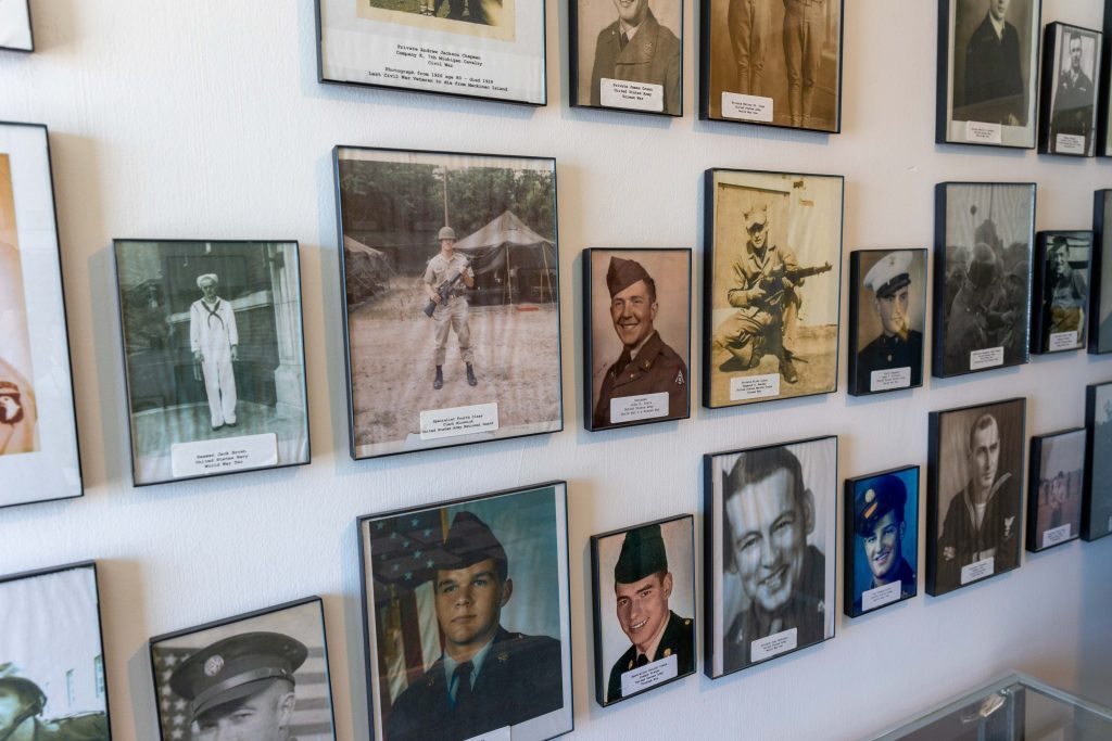 A wall of photographs inside Mackinac Island's Stuart House City Museum shows island residents who served in the Armed Forces