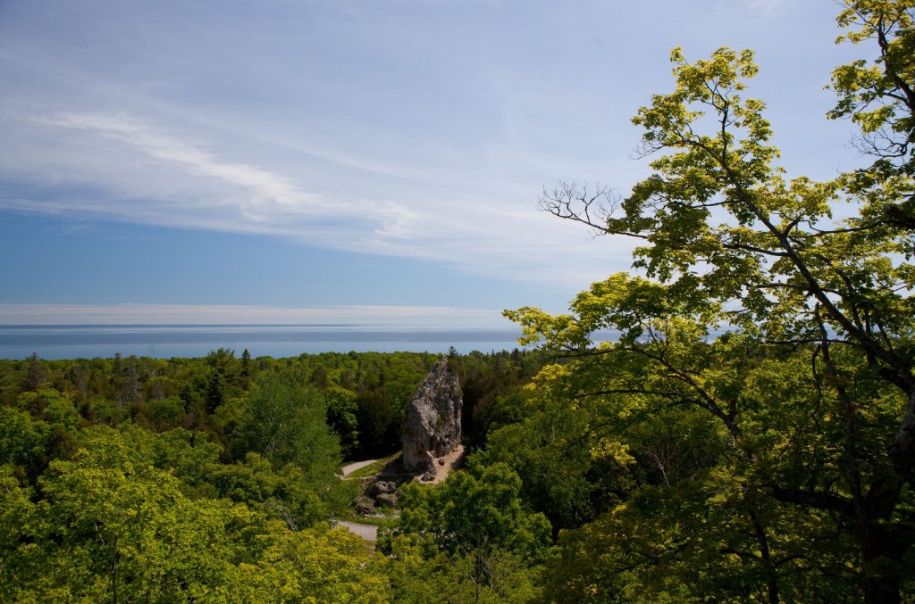 Mackinac Island's Sugar Loaf is framed by the forest of Mackinac Island State Park and the Great Lakes beyond