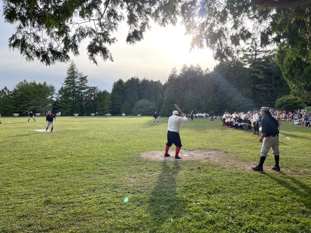 A batter waits for the pitch as the crowd and umpire look on in a vintage base ball game on Mackinac Island