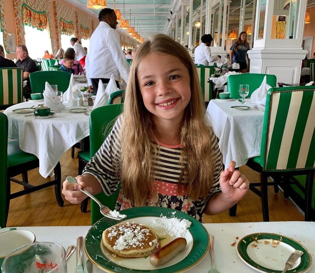 A young girl enjoys a breakfast of pancakes and sausage in the dining room of Mackinac Island's Grand Hotel