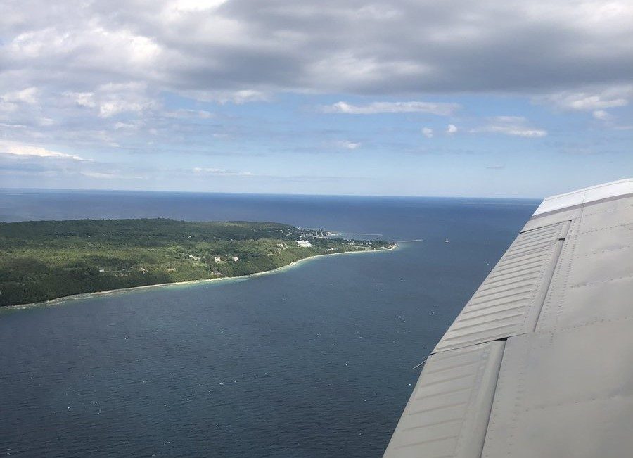 View out window of airplane above Mackinac Island