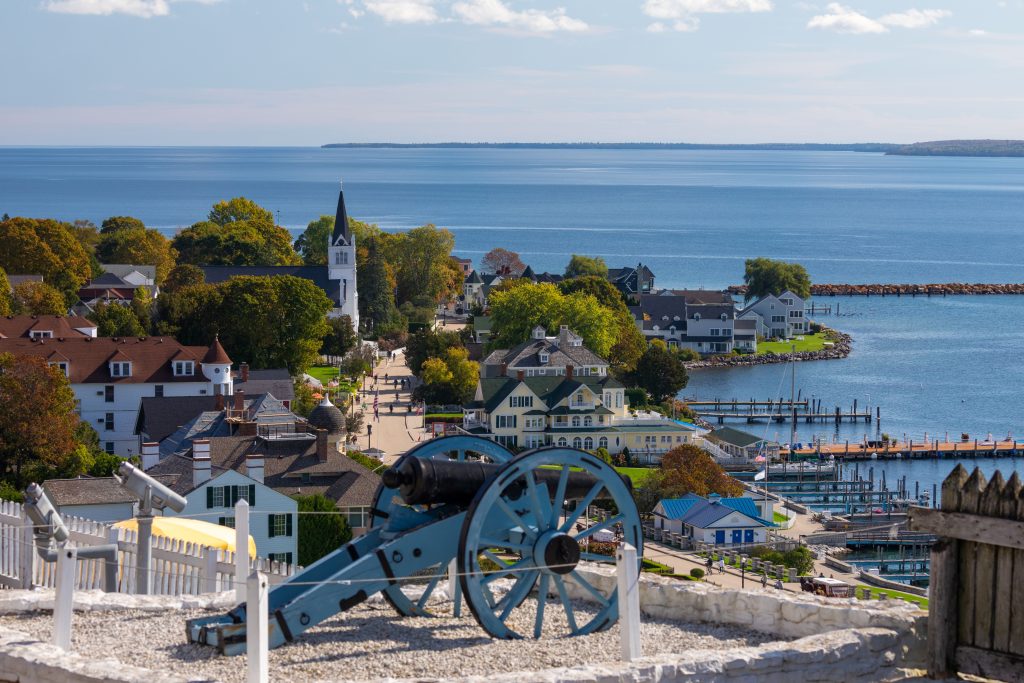 A cannon sits on the bluff at Fort Mackinac above Ste. Anne’s Church and the Mackinac Island harbor below