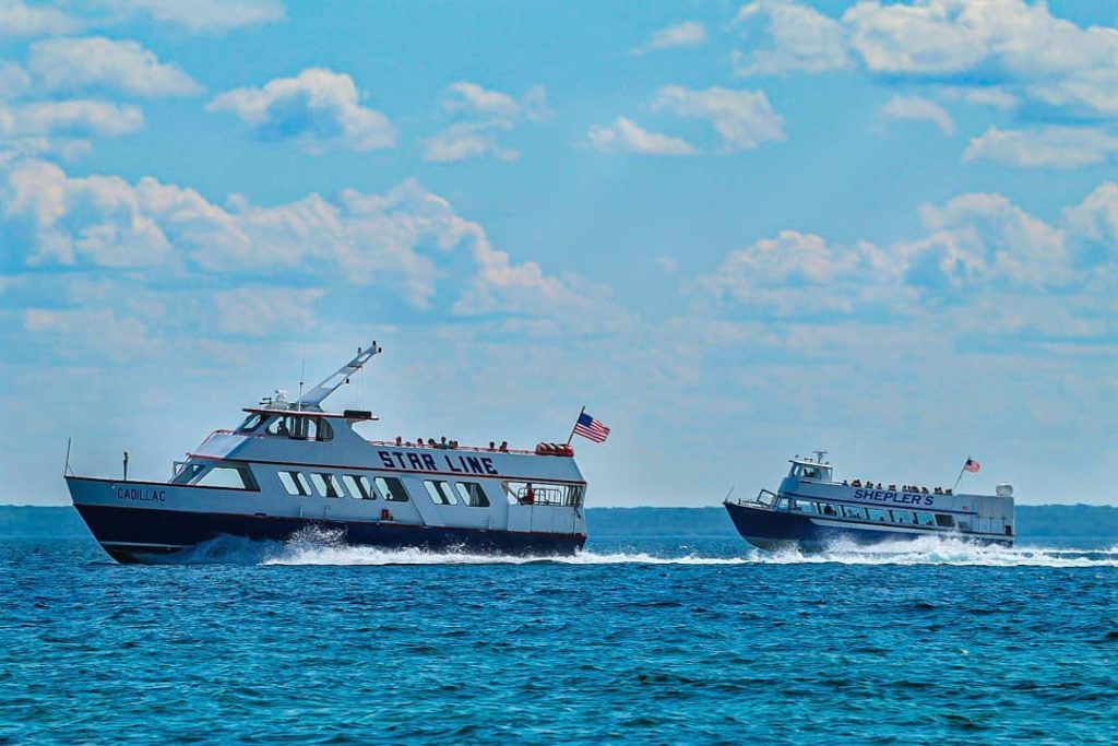 Star Line and Shepler's ferry boats sail through the water near Mackinac Island.