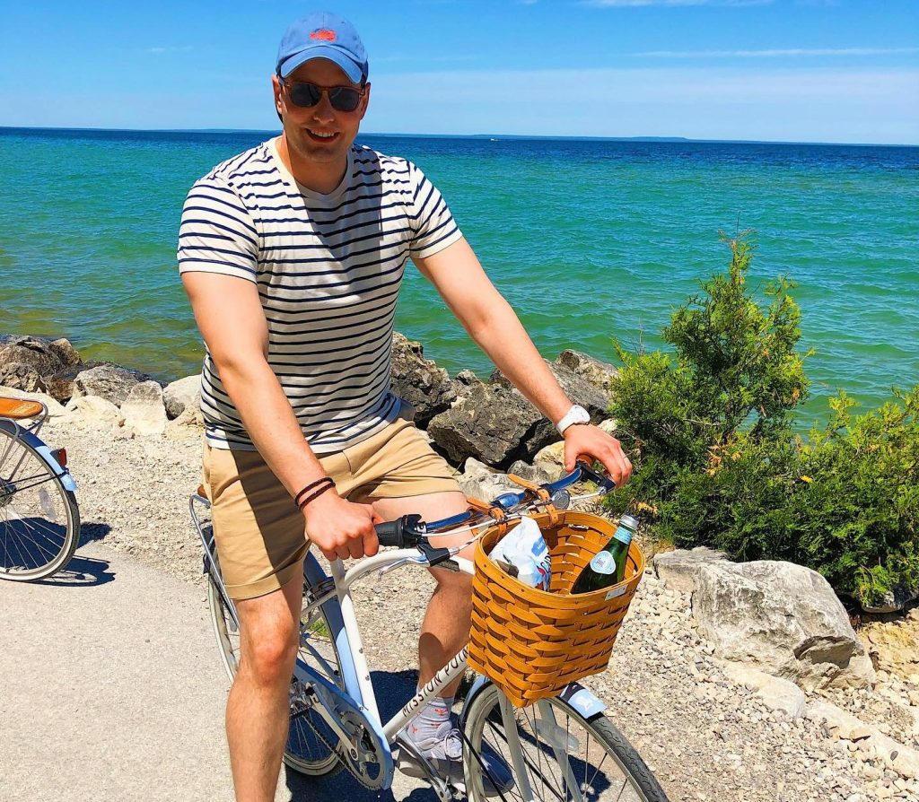 A man pauses while riding a bicycle along the waterfront on Mackinac Island