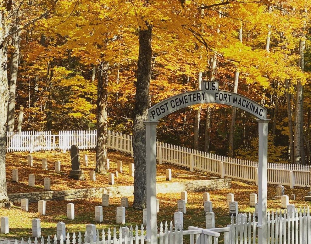 Yellow leaves cover the Fort Mackinac Post Cemetery on a sunny fall day