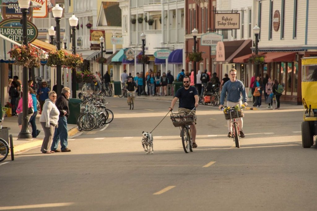 Dog Running with Owners on Bikes on Main Street – Mackinac Island Tourism Bureau