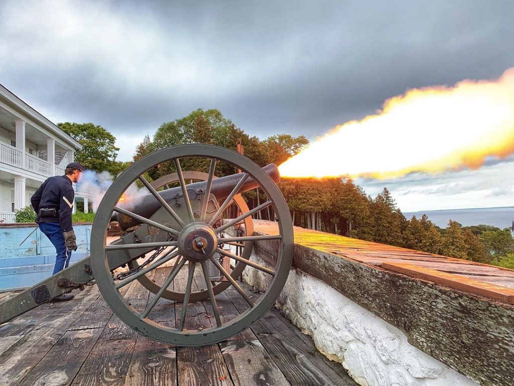 A historical interpreter blasts the cannon at Mackinac Island's Fort Mackinac