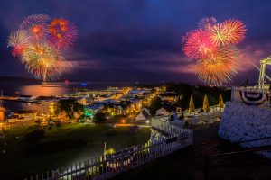 Fourth of July fireworks blast over Mackinac Island at night as seen from up on the bluff at Fort Mackinac