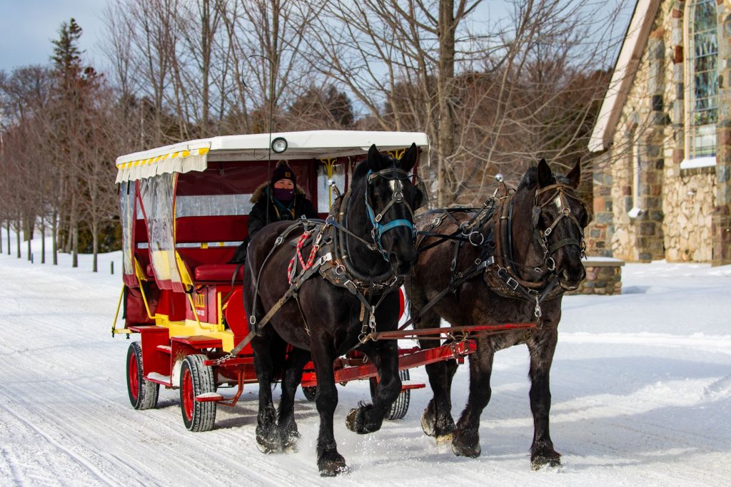 A horse-drawn taxi passes a Mackinac Island church on a snowy winter day