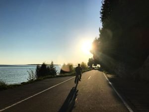 Man Riding Bike on Highway During Sunrise on Mackinac Island