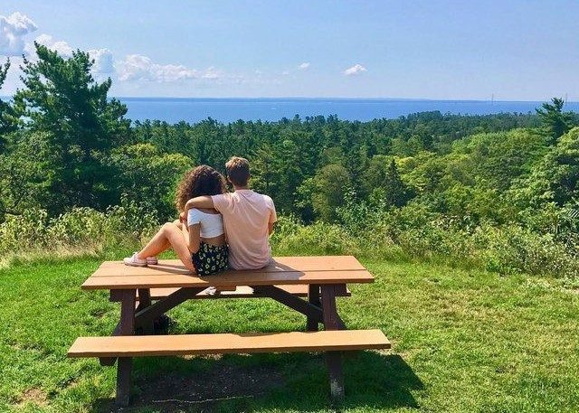 A young couple sits atop a picnic table outside Fort Holmes on the highest point of Mackinac Island