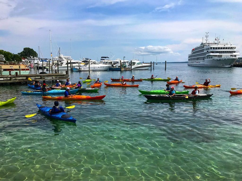 View of Busy Dock Crowded With Cruise Ships, Boats and Kayakers in Waters Surrounding Mackinac Island