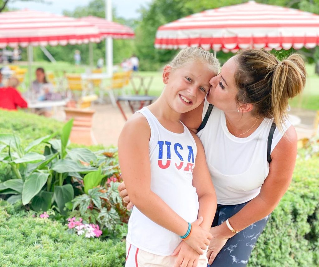 A mother kisses her daughter on the patio at Mackinac Island's Jockey Club