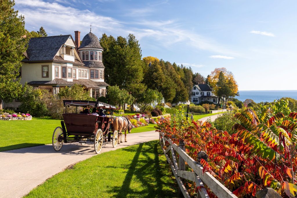 Horse-drawn carriage passes by Victorian cottages on Mackinac Island’s East Bluff