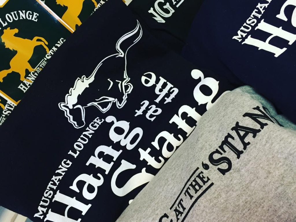 T-shirts with a "Hang at the Stang" motto from Mackinac Island's Mustang Lounge