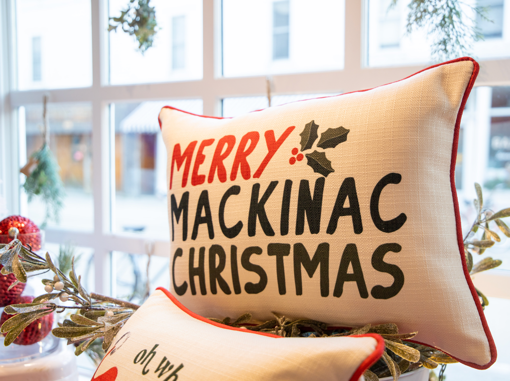 Decorative Merry Mackinac Christmas pillow in Mackinac Island storefront window