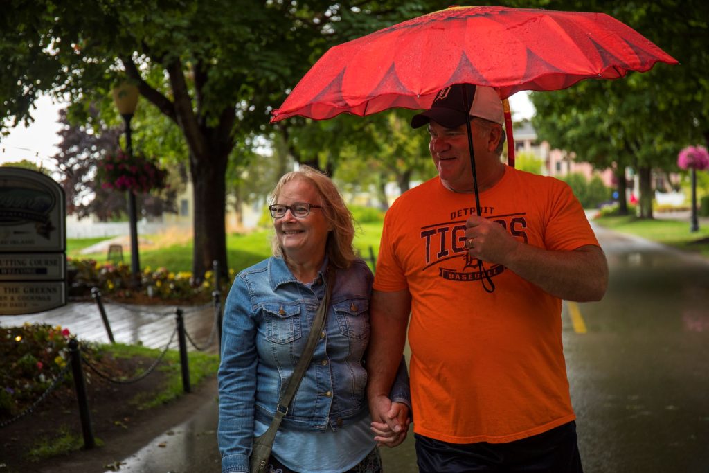 A couple walks under an umbrella on a rainy day on Mackinac Island