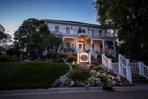 The sign out front of the Cloghaun B&B lights up as night falls on the historic Mackinac Island inn