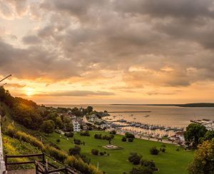The sun rises into the clouds beyond Marquette Park and the Mackinac Island marina on a beautiful morning on Mackinac Island